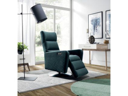 Relaxačné kreslo OSTI v interiéri, tmavozelené polohovacie kreslo pri lampe v modernej miestnosti, šikmý pohľad.