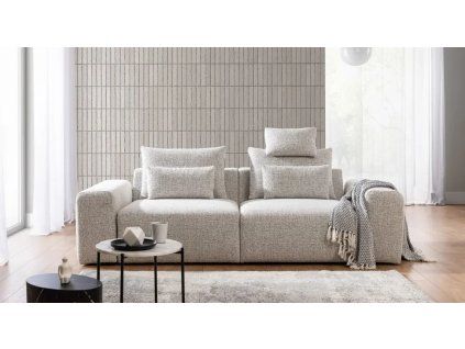Pohovka LUNA SOFA 1 (1,5BL + 1,5BP) v svetlom krémovom prevedení v obývačke, pohľad spredu so stolíkom, lampou a dekou.