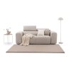 Pohovka RIPLE Sofa 3 v svetlobéžovej poťahovej látke zobrazená spredu v jemnom aranžmáne s kobercom, dekoračnými vankúšmi, prehozom, stolíkom a stojacou lampou.
