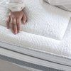 Matrac LUSSA – detail prešívaného poťahu COLLAGEN a bočnej sieťoviny s rukou na povrchu.