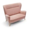 Dvojmiestna pohovka NAOMI sofa 2 v ružovej farbe, šikmý pohľad sprava s dôrazom na zaoblené boky a drevené nohy na bielom pozadí.