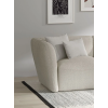 Dvojsedová pohovka STELVIO Sofa vo svetlobéžovej farbe, bočný detail lakťovej opierky a mäkkého operadla v obývačke.