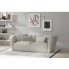 Dvojsedová pohovka STELVIO Sofa vo svetlobéžovej farbe v interiéri, šikmý pohľad zboku na tvar a zaoblené boky.