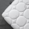 Matrac Monaco Dream, detail bieleho poťahu s veľkými kruhovými prešívanými plochami, záber zblízka.